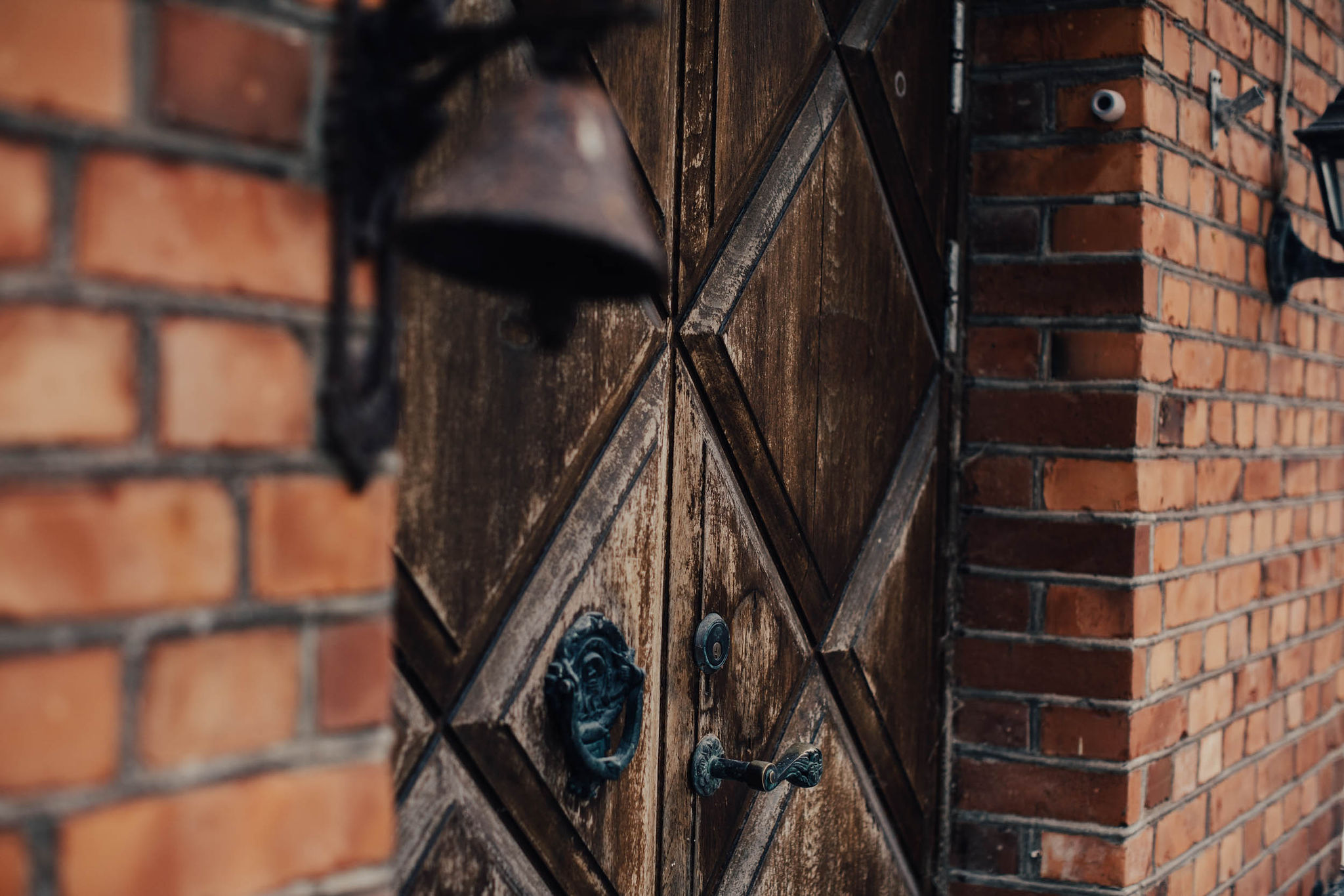 En tegelfasad och en äldre dörr.